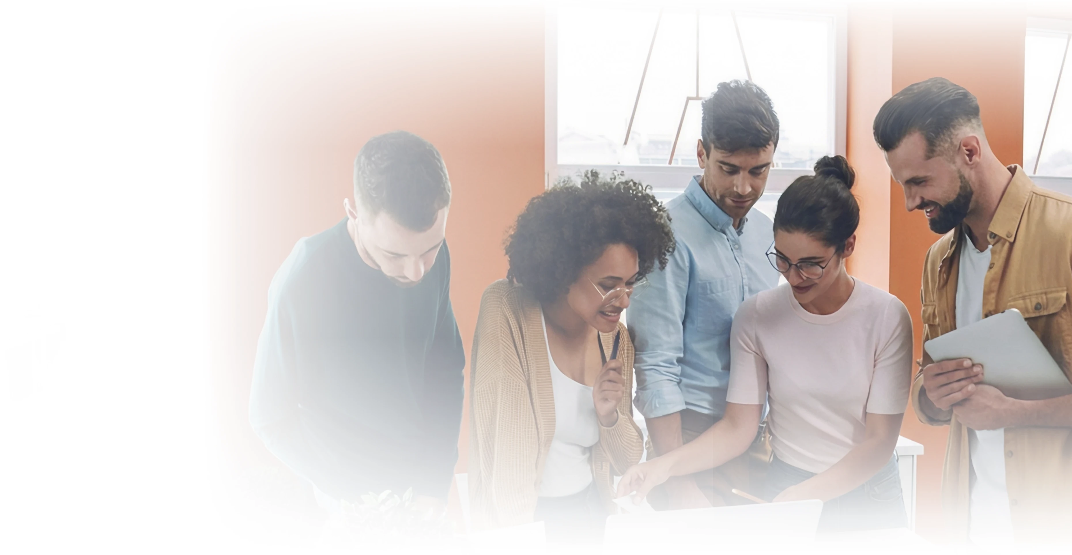 Group of five coworkers collaborating at a table, reviewing documents together.